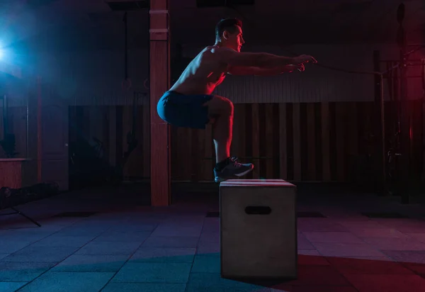 Muskelprotz Trainiert Einer Dunklen Turnhalle Das Springen Auf Einer Holzkiste — Stockfoto