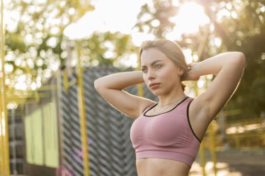 Güneşli bir günde spor sahasında kasıtlı olarak sıska bir kadının portresi.