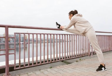 Çekici, sağlıklı, formda kadın bacaklarını açıyor. Sağlıklı bir yaşam tarzı. Açık hava egzersizi.