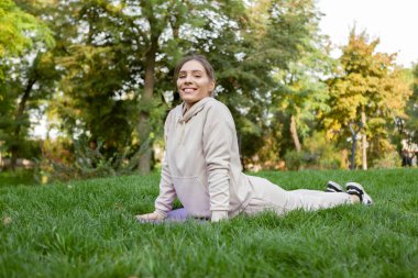 Açık havada kobra pozu veren sıska bir kadın. Bhujangasana pozu