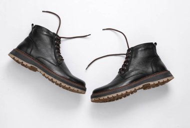 Beyaz arka planda bağcıkları çözülmüş şık erkek deri botları.