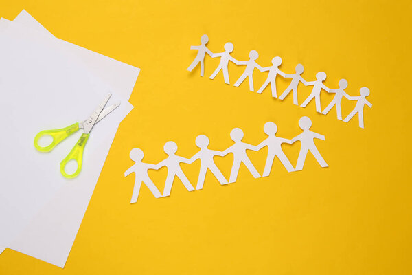 Цепь людей с ножницами на жёлтом фоне