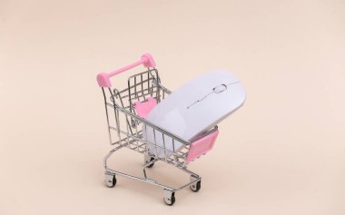 Bej arka planda modern bilgisayar faresi olan mini alışveriş arabası