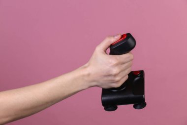 Pembe arka planda eski joystick 'i tutan eller. Eski oyun. 80 'lerin retro dalgası