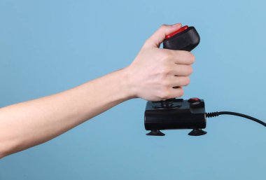 Eller mavi arka planda retro joystick 'i tutuyor. Eski oyun. 80 'lerin retro dalgası