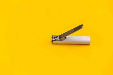 Sarı arka planda tırnak makası. Yakın plan.