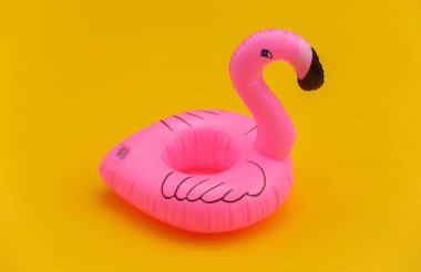 Sarı arka planda şişirilebilir pembe flamingo. Yaz tatili kavramı.