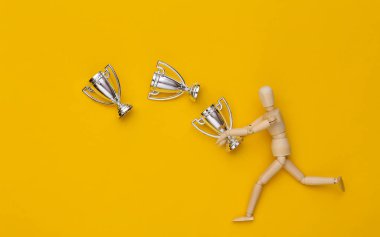 Sarı arka planda gümüş kukla tutan tahta kukla.