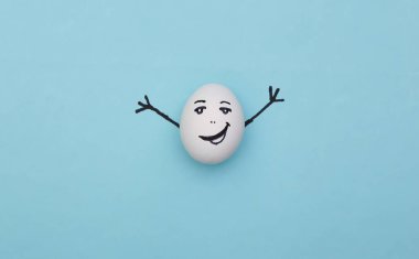 Mavi arka planda elle çizilmiş mutlu yumurta.