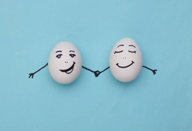 Mavi arka planda elleri çizilmiş mutlu çift yumurtaları