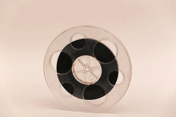 Reel of magnetic audio tape on beige background