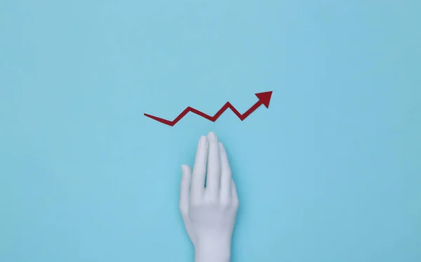 Mannequin's hand and red growth arrow tending upward on a blue background.