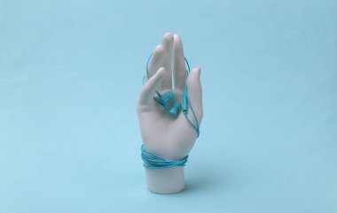 Mavi arka planda beyaz manken eli kulaklıklara sarılı.