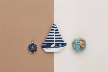 Yelkenli, pusula ve kahverengi arkaplanda küre. Seyahat konsepti. Üst görünüm