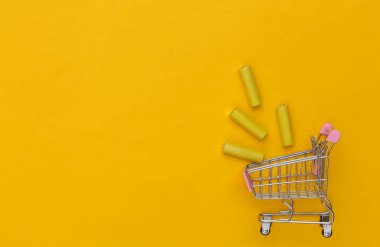 Sarı arka planda dört sarı AA pilli alışveriş arabası. Üst görünüm