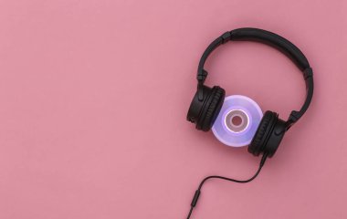 Pembe arka planda CD 'si olan Stereo kulaklıklar. Üst görünüm