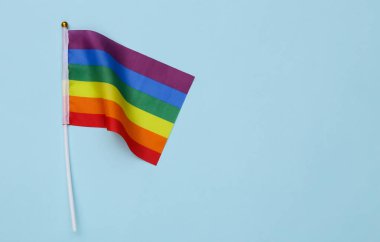 Mavi arka planda LGBT gökkuşağı bayrağı. Hoşgörü, özgürlük, gay geçidi