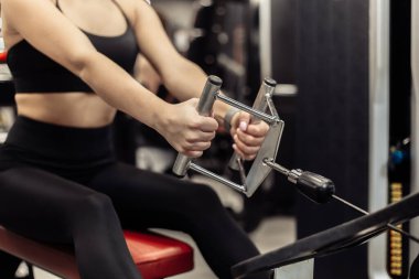 Modern bir spor salonunda kürek çeken zinde bir kadın.