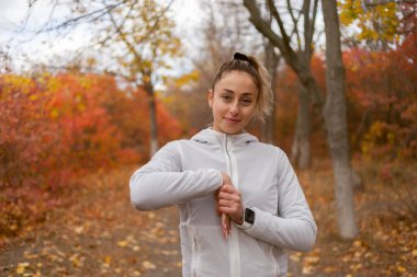 Açık havada egzersiz yapan çekici fit bir kadın. Kız sonbahar ormanında esneme hareketleri yapıyor.