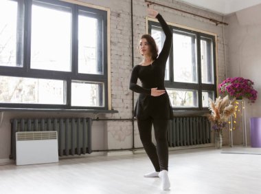 Dans stüdyosunda egzersiz yapan kadın dansçı.