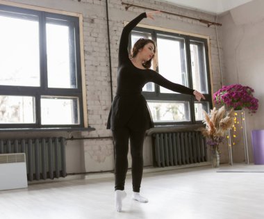 Dans stüdyosunda egzersiz yapan kadın dansçı.