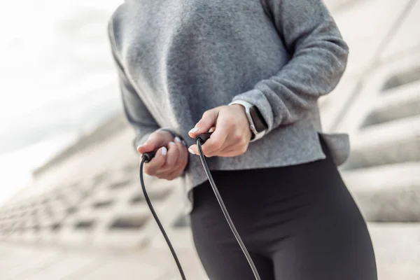 Sport fit woman with a skipping rope in her hands outdoors. Healthy lifestyle