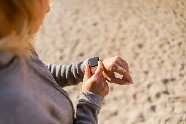 Fit woman monitors her heart rate on a smart bracelet