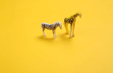 Sarı arka planda zebra ve zürafa figürleri