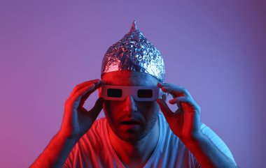 Folyo şapkalı çılgın sakallı adam ve kırmızı mavi ışıklı 3D gözlüklü adam.