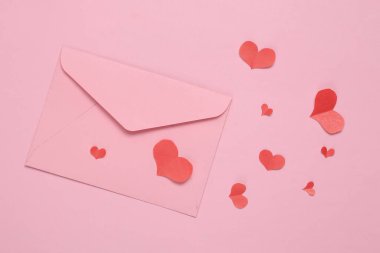Kağıt Kesiği Kırmızı Kalpler ve pembe arka planda bir zarf. Sevgililer Günü konsepti