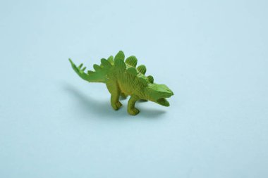 Mavi arka planda oyuncak dinozor.