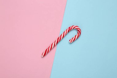 Mavi pembe arka planda Noel çizgili şeker kamışı.