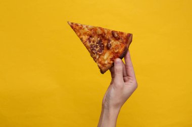 El yapımı, sarı arka planda ev yapımı bir pizza.