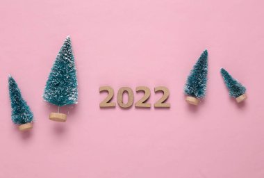 2022 ve pembe arka planda mini noel ağacı. Noel, yeni yıl kompozisyonu
