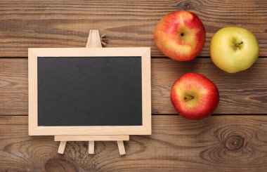 Tahta tahta ve elmalar ahşap masada. Kopya alanı olan boş bir karatahta. İş, eğitim, öğrenme kavramı.
