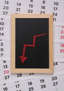 Mavi arka planda büyüyen bir ok ve takvim olan küçük tebeşir tahtası. İş konsepti