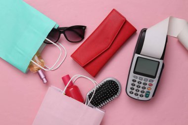 Ödeme terminali, pembe arka planda aksesuarları olan alışveriş çantası. Satın alma konsepti için ödeme. Üst görünüm