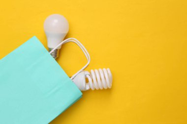 Sarı arka planda ampulleri olan bir alışveriş paketi. Üst görünüm