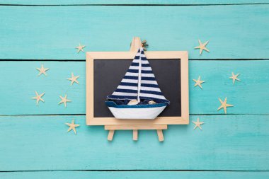 Mavi ahşap arka planda yıldız balıkları ve küçük tebeşir tahtası. Seyahat kavramı.