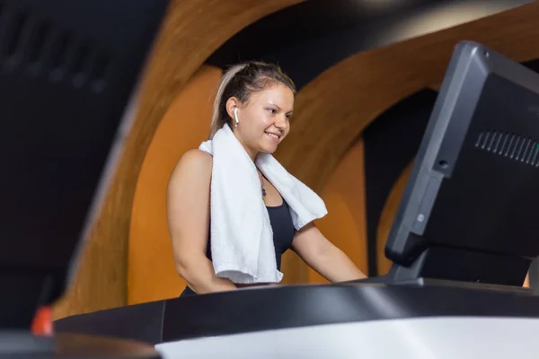 Healthy happy fitness woman in sportswear on a treadmill in a gym