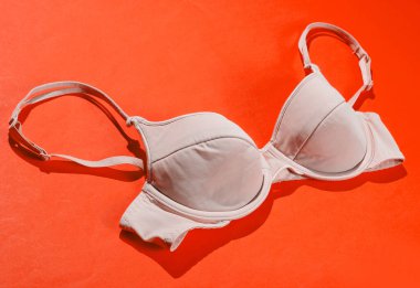 Turuncu arka planda rahat kadın sütyeni. Güzel iç çamaşırı. Yan görünüm