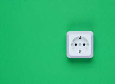 Yeşil arka planda beyaz plastik prizler. Kopya alanı olan duvar. Minimalizm