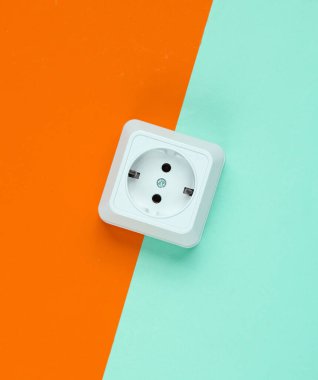Renkli arka planda beyaz plastik priz. Minimalizm