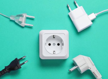 Elektrik bağımlılığı kavramı. Mavi arkaplanda elektrik prizlerinin yanında bir sürü elektrik prizi var