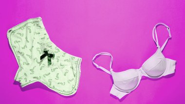 Pembe arka planda kadın sütyeni ve külotu. Gece iç çamaşırı. Üst görünüm