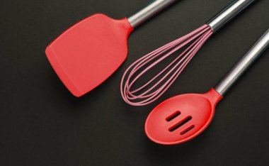 Siyah arka planda silikon mutfak aletleri. Üst görünüm.