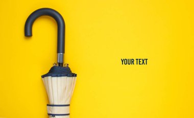 Sarı arka planda şemsiye kancası var. Üst Manzara. Sonbahar aksesuarları. Boşluğu kopyala