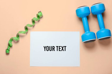 Fotokopi alanı için beyaz kağıt, plastik halterler, sarı arka planda cetvel. Yaratıcı fitness arkaplanı