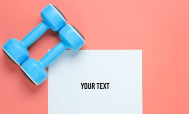 Fotokopi alanı için beyaz kağıt, pembe arka planda plastik halterler. Yaratıcı fitness arkaplanı