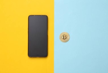 Mavi-sarı arka planda Bitcoin ve akıllı telefon. Kripto para birimi
